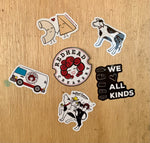 photo of the stickers stuck on to a board. Macaroni and cheese holding hands, solo cow, we heart all kinds, RHC curds on cow, RHC cheese van